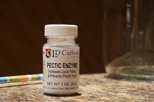 LD Carlson pectic enzyme for clearing cider a small bottle of white granular pectic enzyme on a brown table