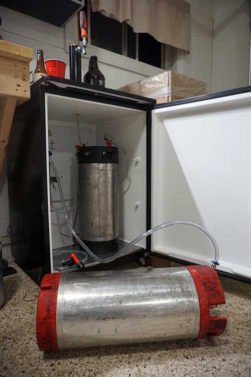 a corney keg on its side being rolled to force carbonate cider